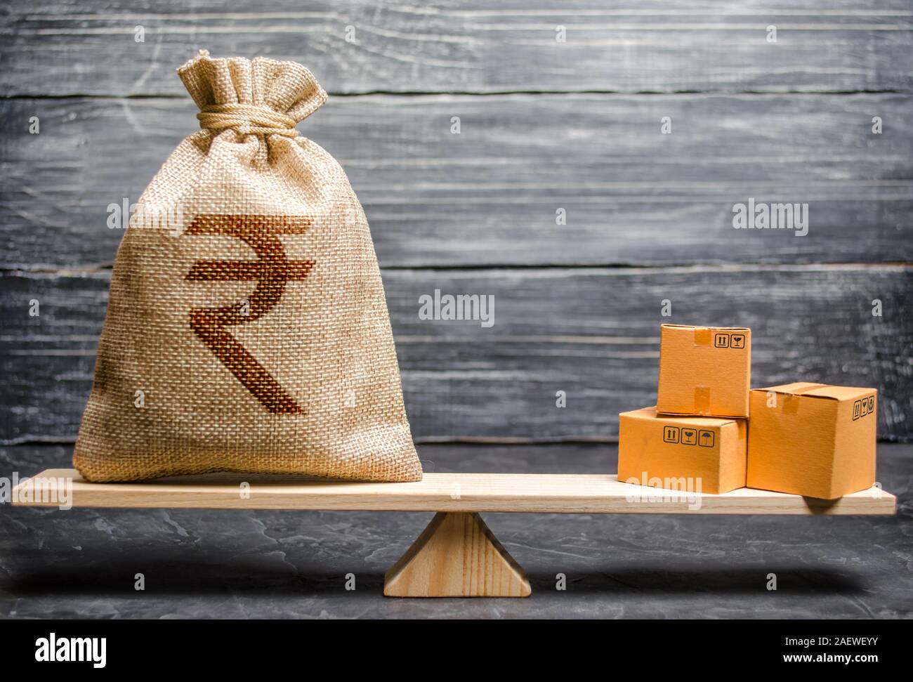 Roupie indienne INR sac d'argent symbole et un tas de boîtes sur les balances. L'équilibre d'échange commercial. L'importation et l'exportation, les processus économiques. Profiter de raccord spécifique fabriquant Banque D'Images