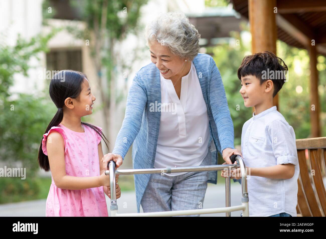 Sœur heureuse d'aider grand-mère marche avec déambulateur Banque D'Images