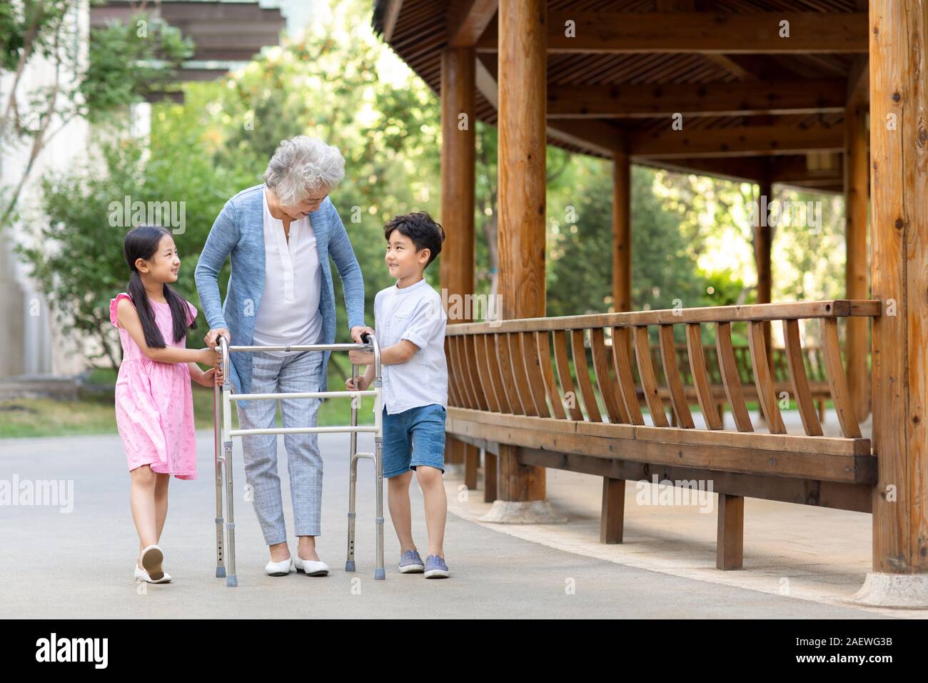 Sœur heureuse d'aider grand-mère marche avec déambulateur Banque D'Images