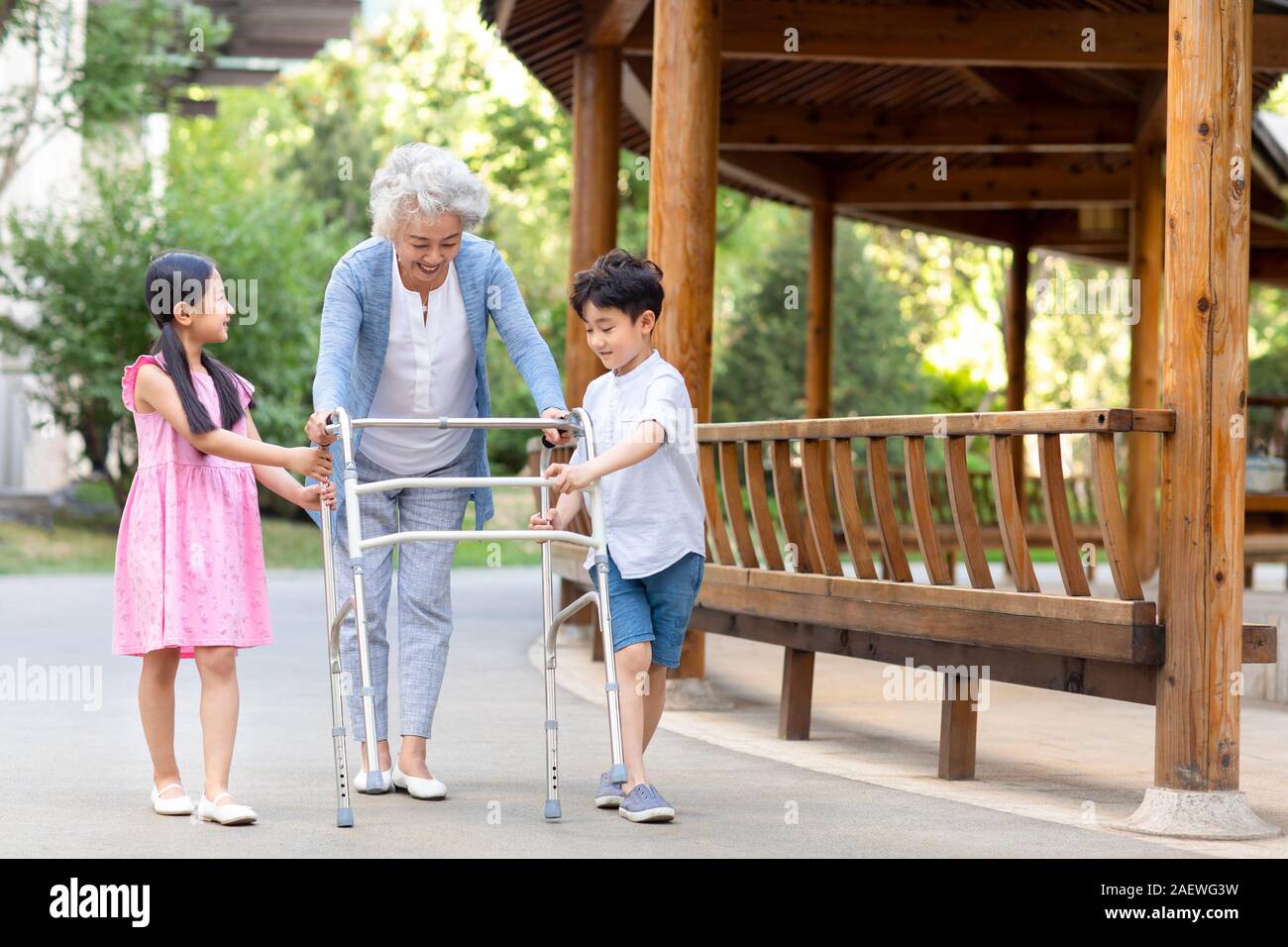 Sœur heureuse d'aider grand-mère marche avec déambulateur Banque D'Images