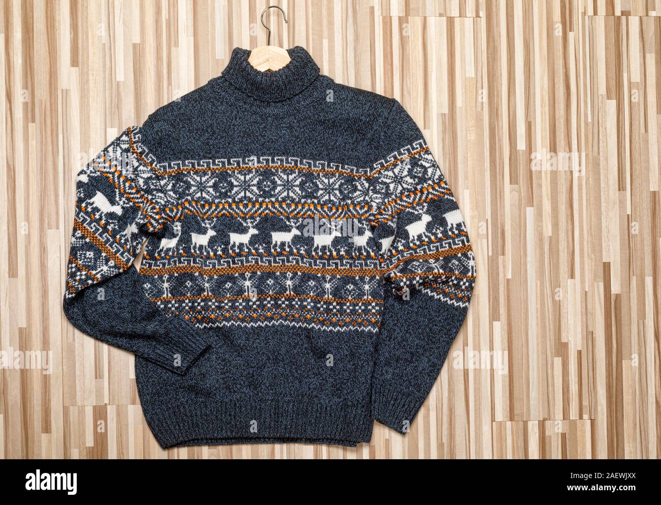 Pull col roulé de Noël tricoté bleu ou gilet de style traditionnel avec un  ornement géométrique scandinave blanc jeté sur fond de bois avec Photo  Stock - Alamy