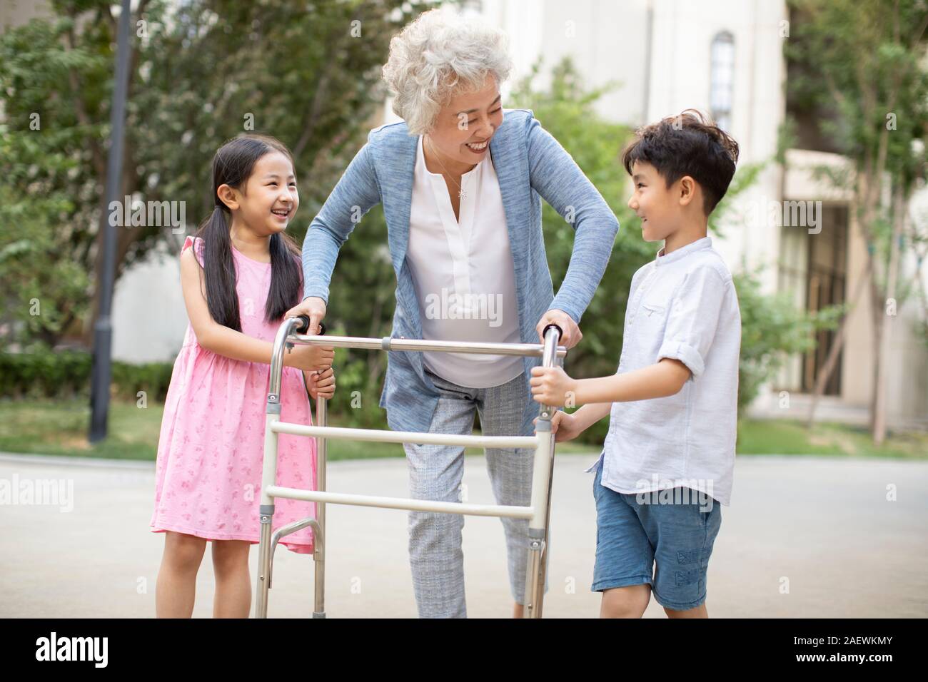 Sœur heureuse d'aider grand-mère marche avec déambulateur Banque D'Images
