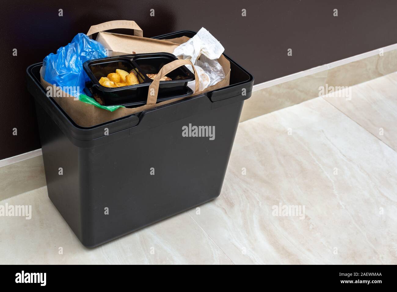 Plein d'ordures poubelle murale marron personne n Photo Stock - Alamy