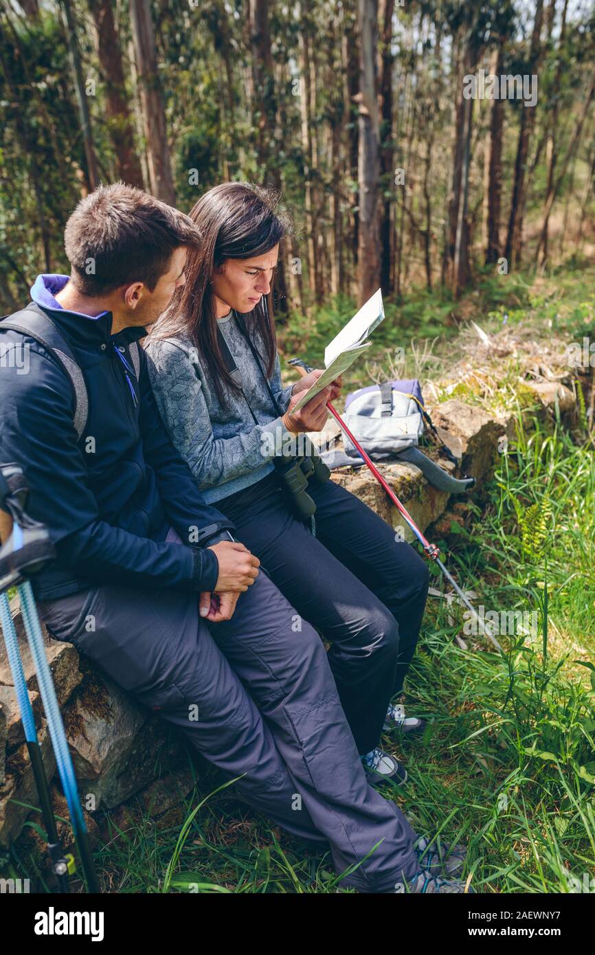 Couple assis trekking en regardant une carte Banque D'Images