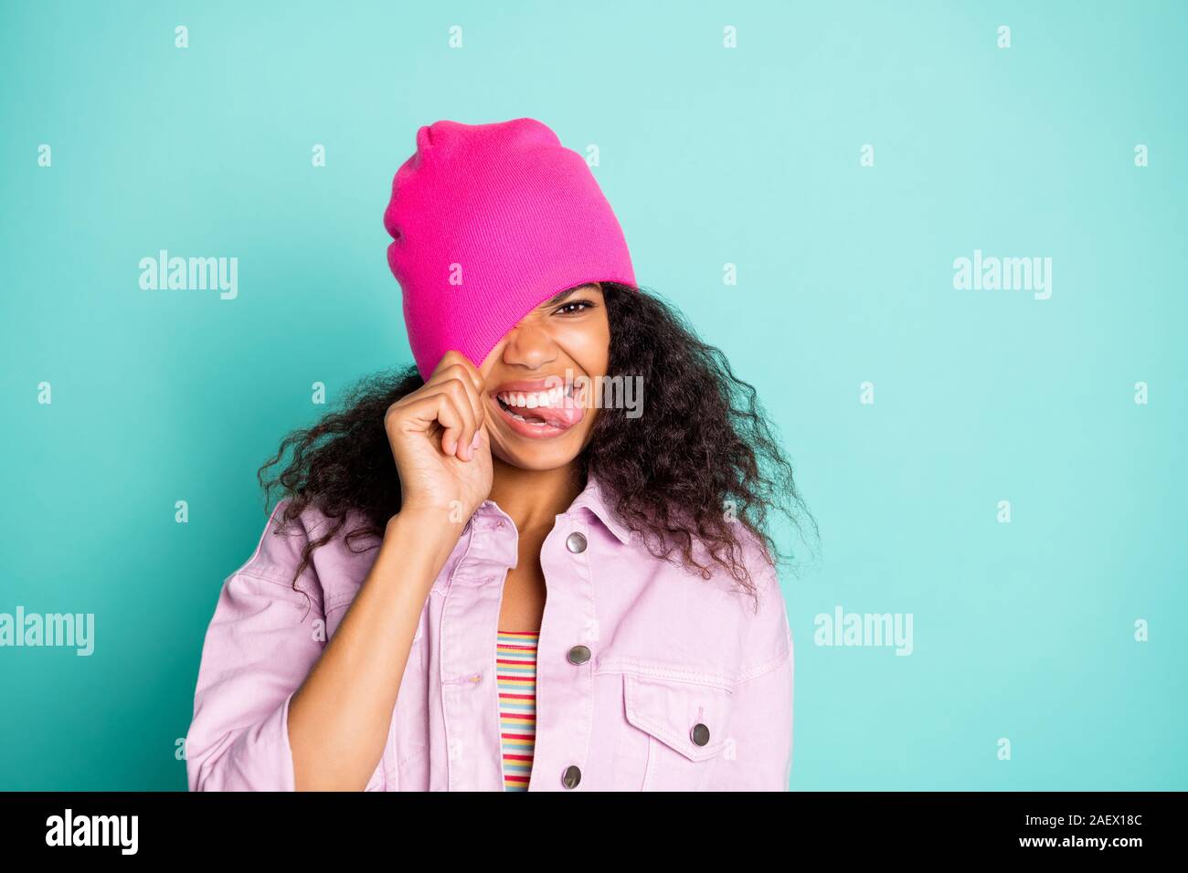 Photo de cheerful impoli rude girl coller sa langue au t-shirt rayé rose veste montrant l'attirant sur sa tête la sarcelle vives isolées Banque D'Images