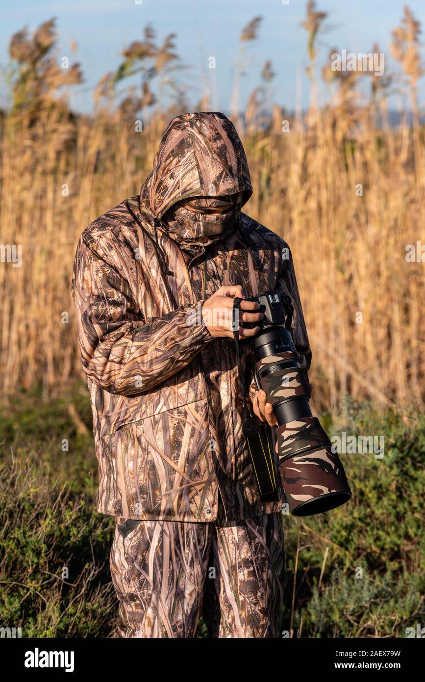 Photographe naturaliste en action, de camouflage et de la caméra, dans le désert. Banque D'Images