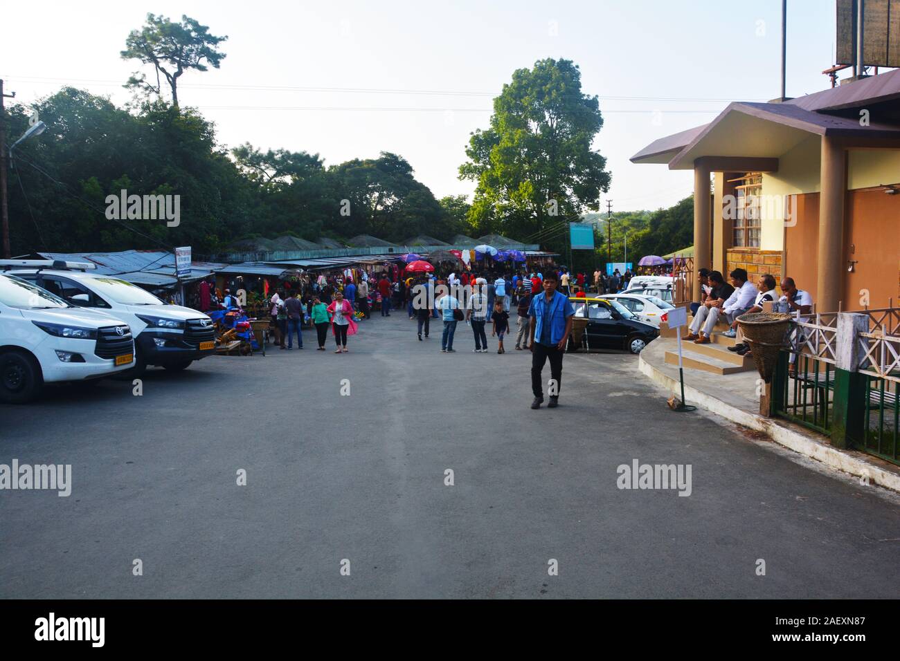 L'aire de stationnement des chutes de l'éléphant, la région de Shillong, Meghalaya avec rangées de voiture, les gens autour de l'itinérance, arbres, ciel ouvert, l'accent sélective. Banque D'Images