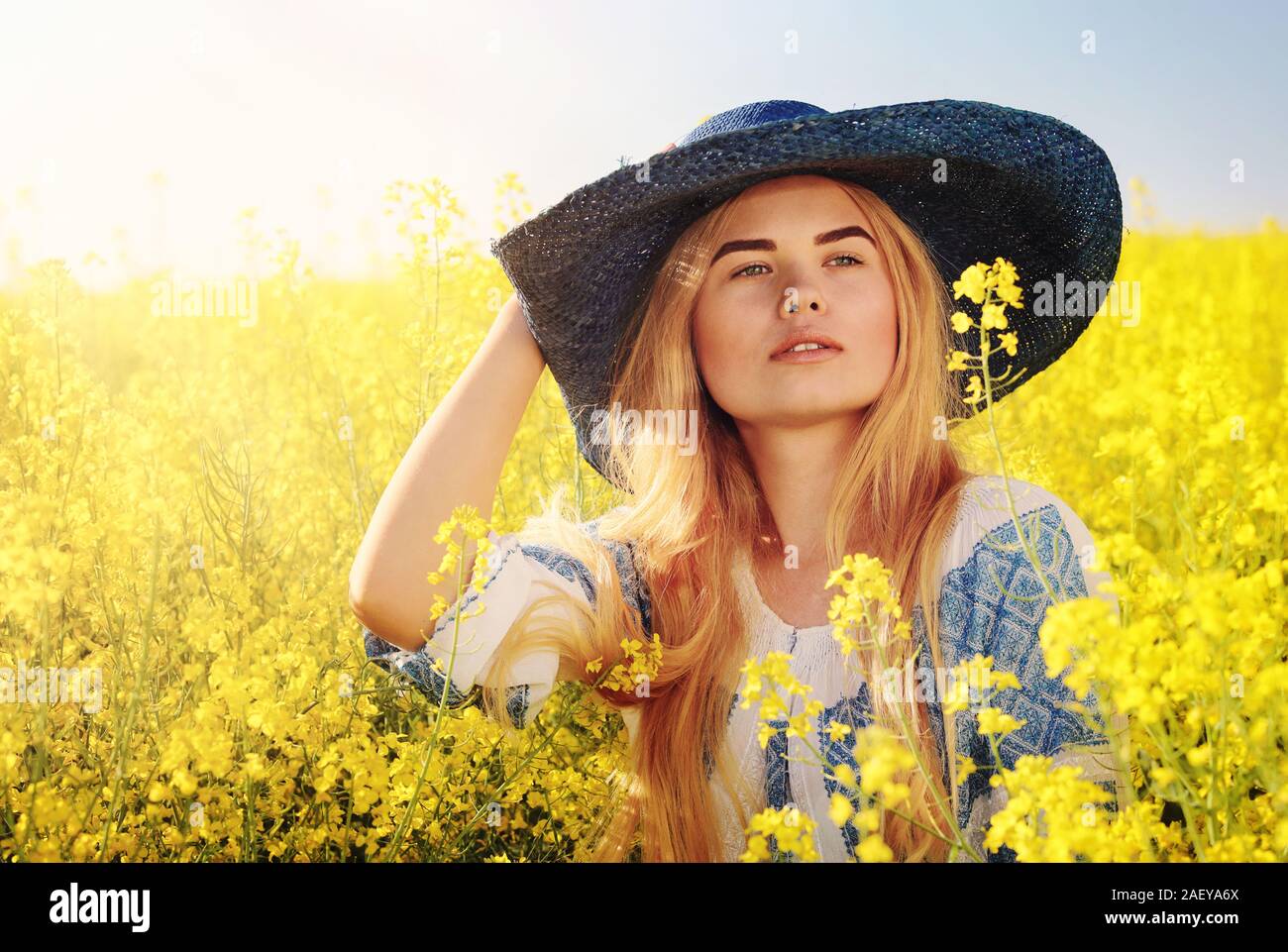 Portrait jeune femme en blouse roumaine (vêtements) sur le colza en fleur champ Banque D'Images