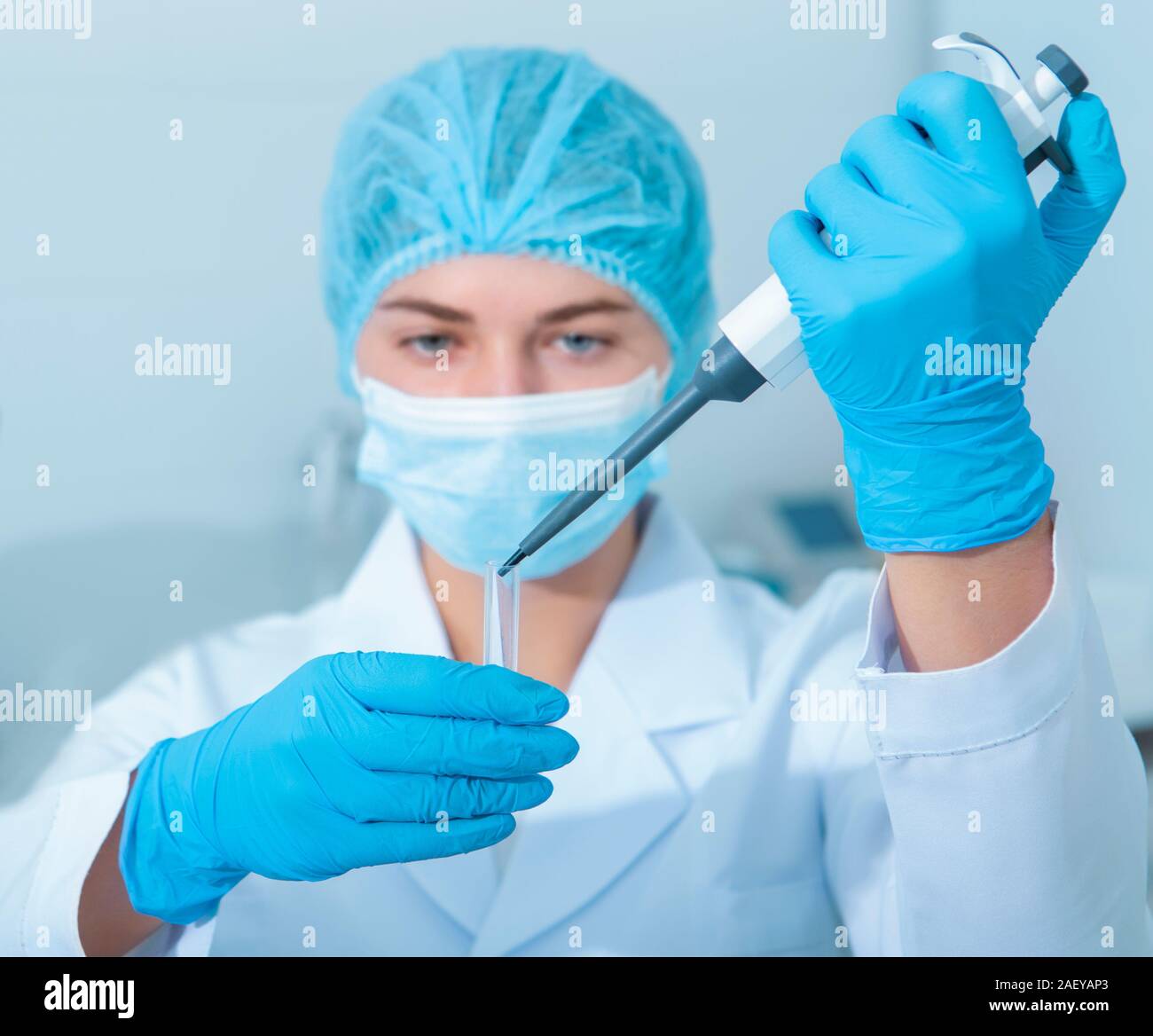 Des échantillons de gouttes jeune scientifique pipete pour tubes à essai, équipement de laboratoire moderne Banque D'Images