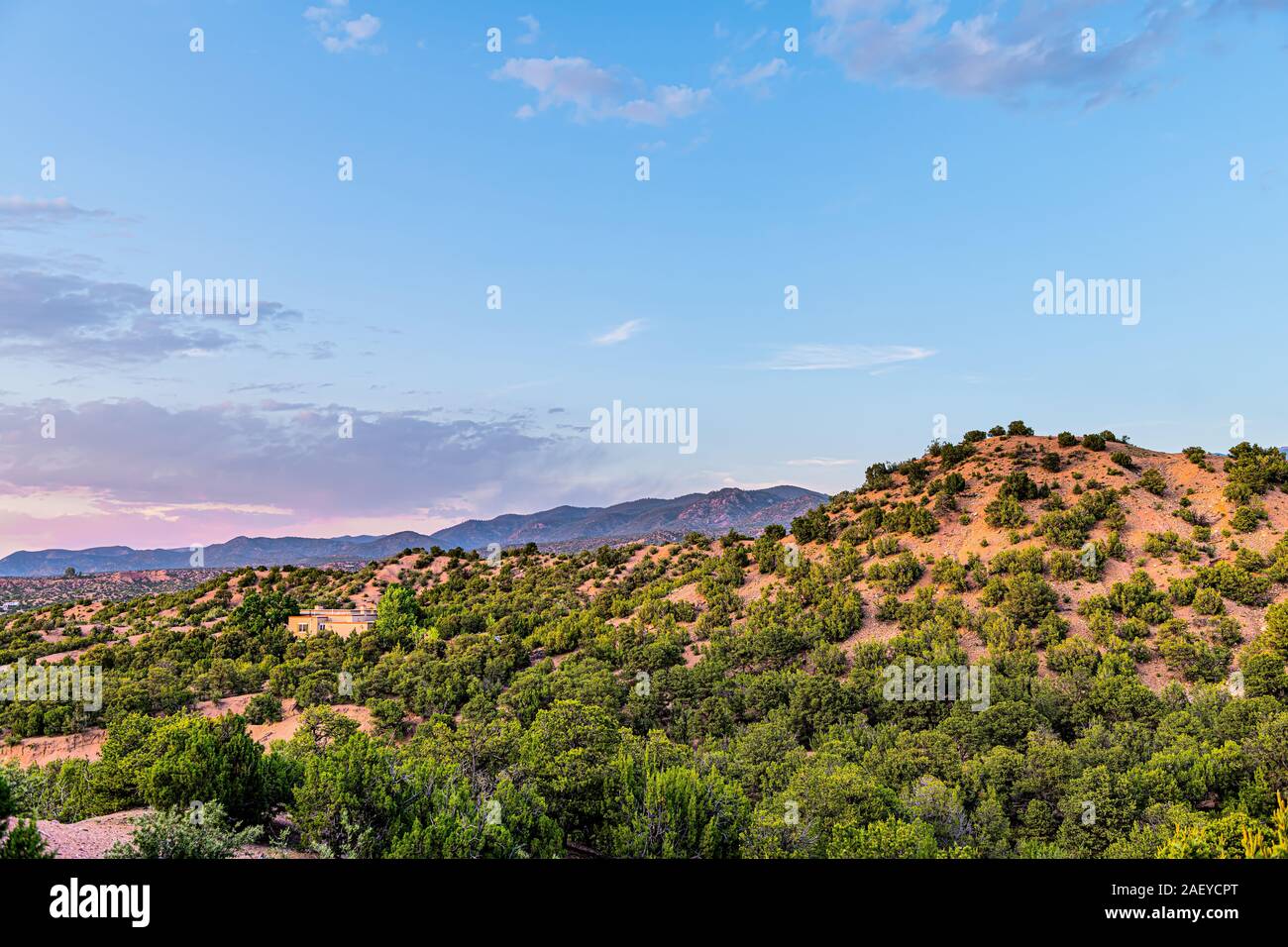 Coucher du soleil au crépuscule rose à Santa Fe, Nouveau Mexique Tesuque quartier communautaire avec des maisons des plantes vertes 3 canards arbres arbustes et bleu ciel nuages Banque D'Images