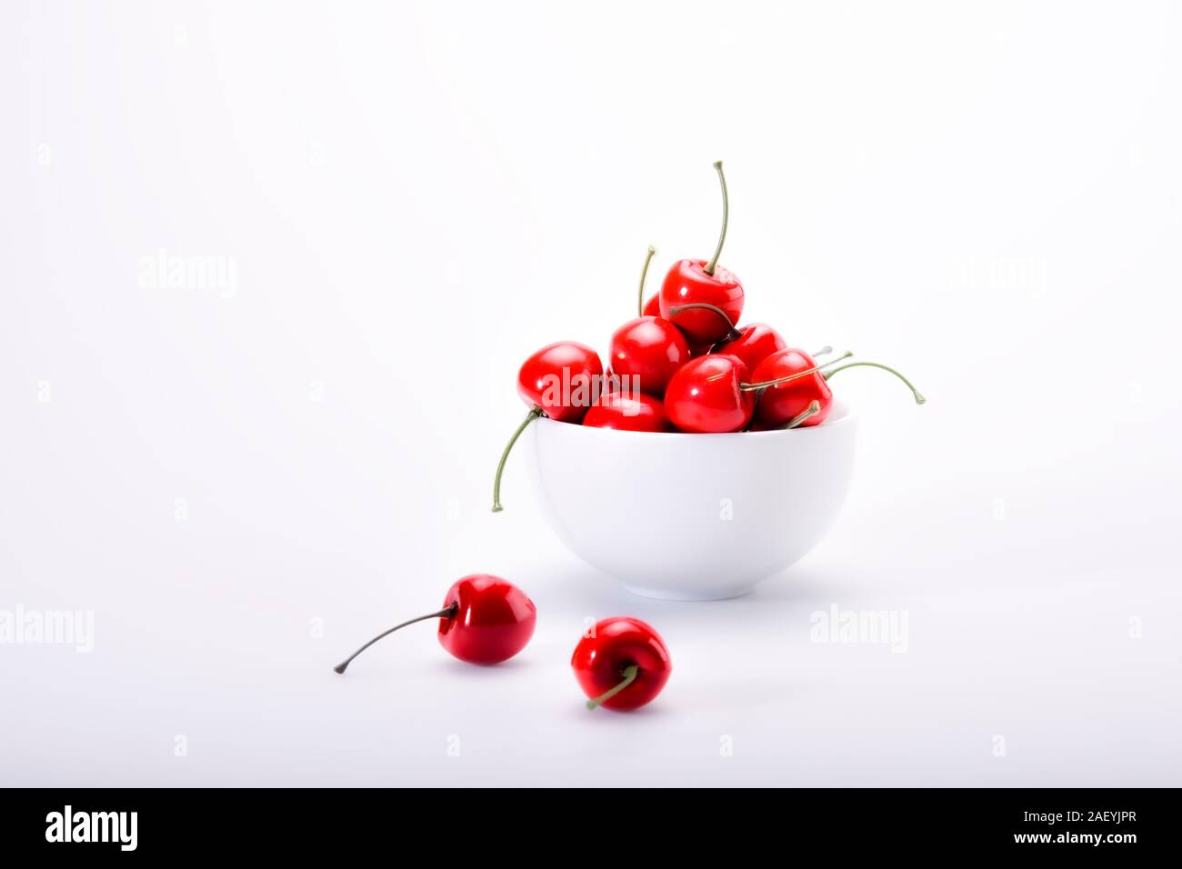 La vie est un bol de cerises. High key photo sur un tableau infini tourné en studio à l'aide d'éclairage Profoto. Banque D'Images