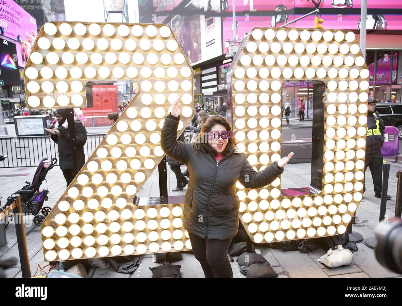 Une femme portant des lunettes 2020 prend une photo de l'enfant debout deux et zéro de l'année 2020 les chiffres quand ils sont allumés dans Times Square à New York le Mercredi, Décembre 11, 2019. Le géant, sept pieds de hauteur de '20' est arrivé sur un camion à plateau sur la 46e Rue et Broadway et sera portée à la partie supérieure d'un Times Square où ils vont se reposer quelques jours avant de remplir le '2-0C2-0' qui s'allume à minuit le soir du Nouvel An pour annoncer le début de la nouvelle année à la fin de la balle Drop. Photo de John Angelillo/UPI Banque D'Images