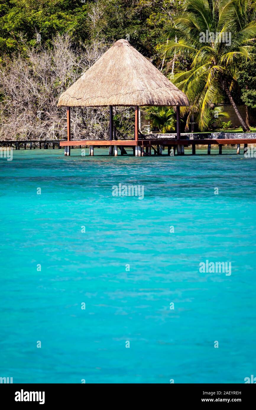 Un palapa et l'eau azur du 'lac des sept bleus' à Bacalar, Quintana Roo, Mexique. Banque D'Images