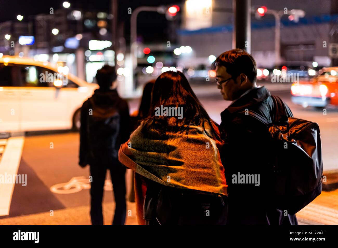 Kyoto, Japon - 9 Avril 2019 : jeune couple de personnes attendant de cross street dans le quartier de Gion au soir sombre nuit à la circulation des voitures et boke Banque D'Images
