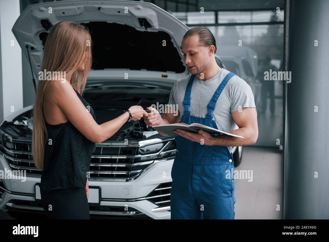 Donner des clés. Résultats de la réparation. Homme confiant montrant quel genre de dommages sa voiture a été prise Banque D'Images