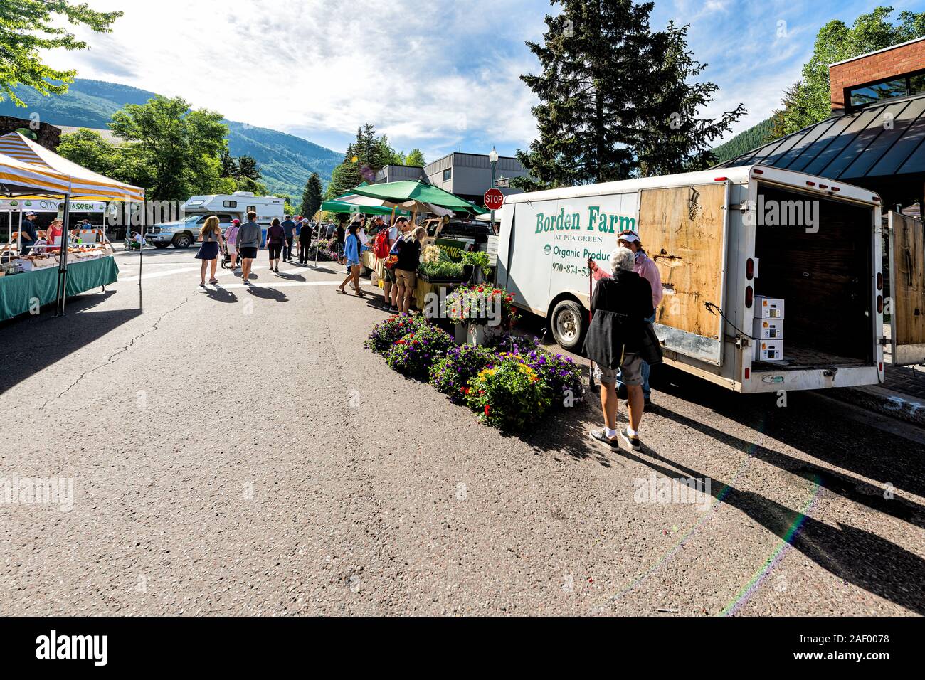 Aspen, USA - 6 juillet 2019 : Vendeurs de produire des fleurs au stand de décrochage dans le marché avec des gens qui marchent dans la rue en plein air Banque D'Images