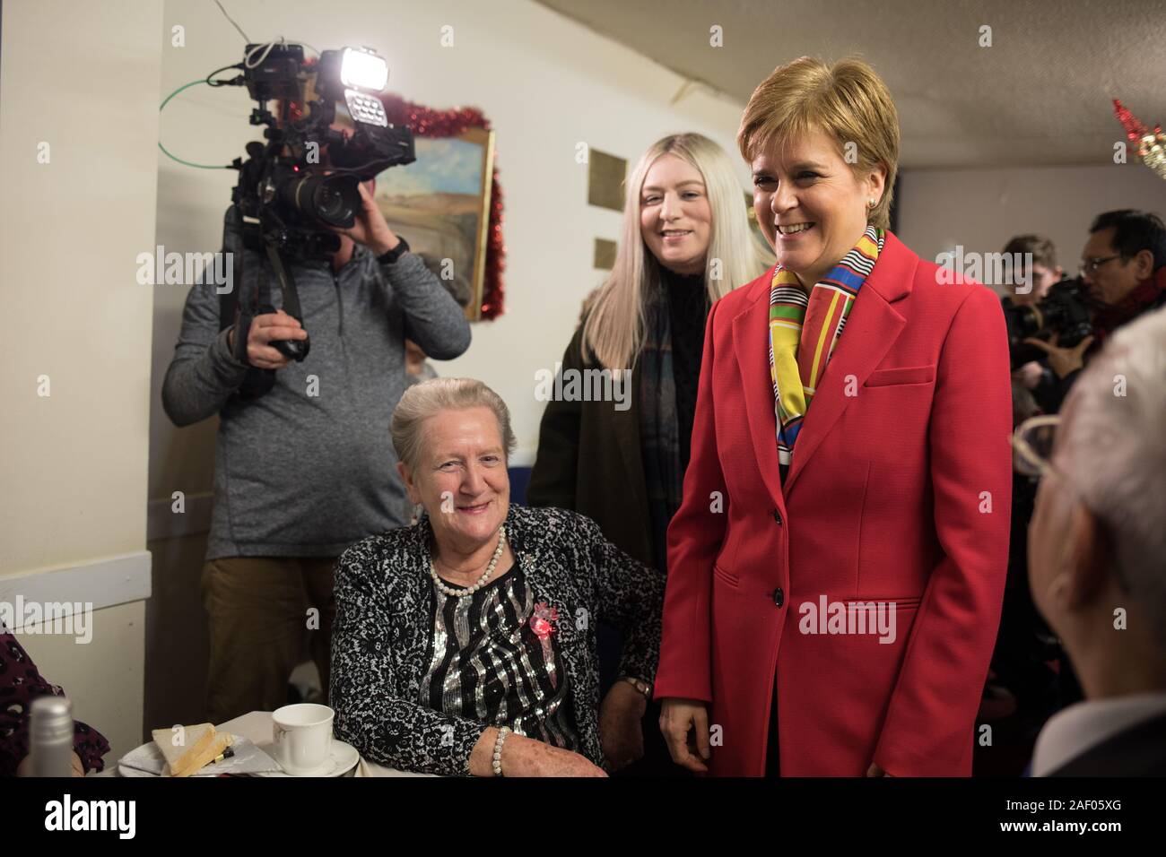 Glasgow, Royaume-Uni, 11 décembre 2019. Nicola Sturgeon, chef du Parti National Écossais, et premier ministre de l'Écosse, rejoint Amy Callaghan, SNP candidat pour East Dunbartonshire circonscription, comme ils sautent dans un dîner de Noël des retraités, à Glasgow, le jour avant la nation va aux urnes dans l'élection générale de 2019. Crédit : Jeremy Sutton-Hibbert/Alamy Live News. Banque D'Images