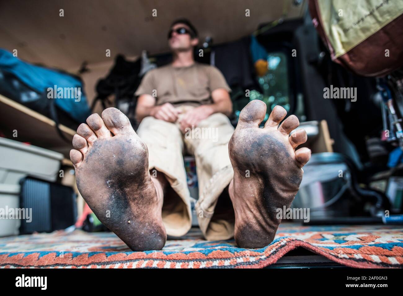 Pieds sales de man hanging out in van Banque D'Images