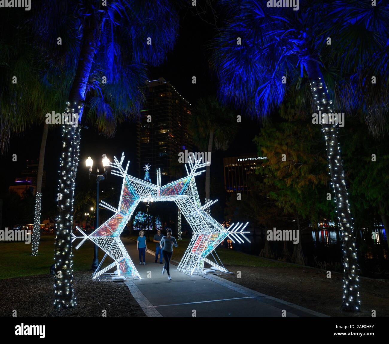 Un coureur avec de nouvelles décorations de vacances au lac Eola Park à Orlando, Floride. Banque D'Images