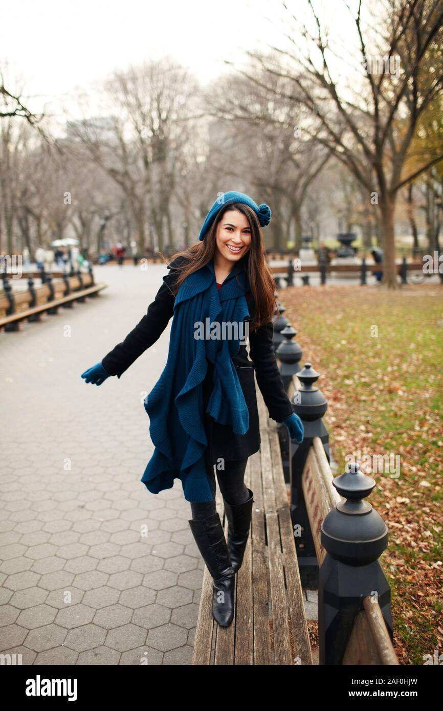 Woman smiling at camera while walking on city park Banque D'Images