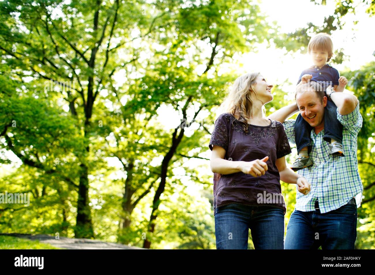 Père Fils holding sur les épaules en parc avec maman jusqu'à Banque D'Images