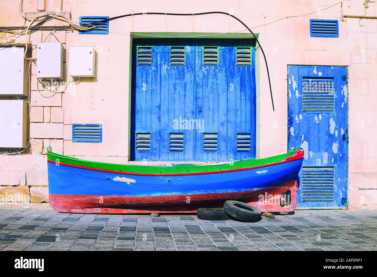 Classique bleu couleur de l'année 2020 dans des couleurs traditionnelles colorées de Malte. Bateau de pêcheur traditionnel sur la chaussée à l'avant du bateau ne Banque D'Images