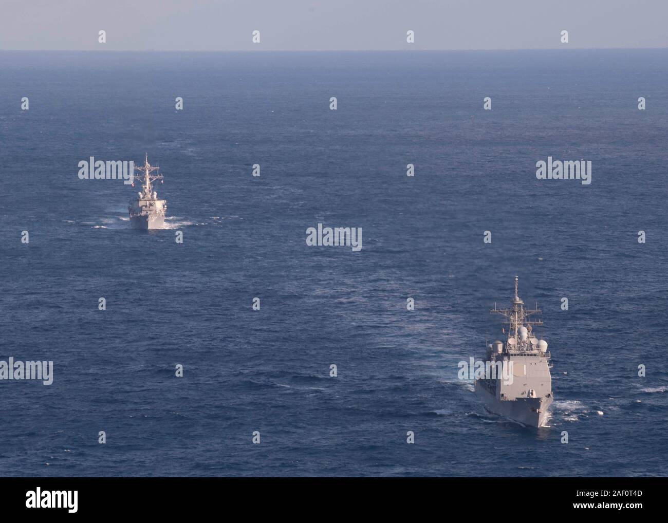 191129-N-OI558-1596 est de la mer de Chine (nov. 29, 2019) La classe Arleigh Burke destroyer lance-missiles USS Barry (DDG 52), gauche, voiles en formation avec la classe Ticonderoga croiseur lance-missiles USS Shiloh (CG 67) au cours d'un exercice de manœuvre pour soutenir les opérations du groupe d'action de surface. Silo est l'avant-déployés dans la 7e flotte américaine zone d'opérations à l'appui de la sécurité et de la stabilité dans la région Indo-Pacifique. (U.S. Photo par marine Spécialiste de la communication de masse Chanel 3e classe L. Turner) Banque D'Images