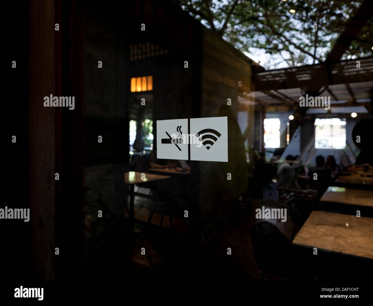 Signalisation sur porte en verre. Aucun signe de fumer, l'icône du signal sans fil wifi pour se connecter sur cafe arrière-plan. Sticker autocollant collé sur des panneaux à l'extérieur de la porte avant Banque D'Images