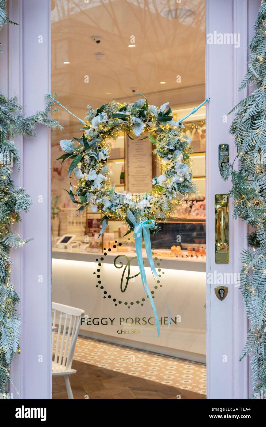 Couronne de Noël à la porte de la boutique de gâteaux Peggy Porschen en décembre. Kings Road, Chelsea, Londres, Angleterre Banque D'Images