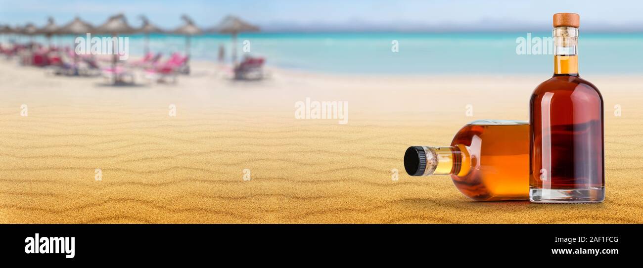 Maison de vacances fun concept. Bouteille de rhum sur la plage arrière-plan. Banque D'Images