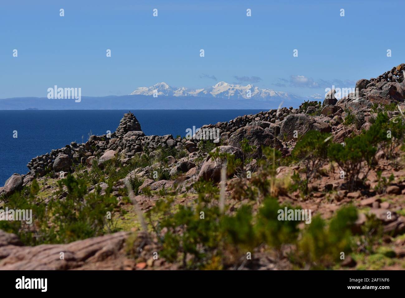 Cairn de pierre à l'île de Taquile avec vue sur la cordillère des Andes en arrière-plan le lac Titicaca, le Pérou, Amérique du Sud Banque D'Images