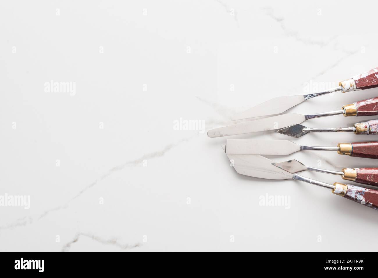 Vue de dessus de spatules pour dessiner sur le métal en surface blanche with copy space Banque D'Images