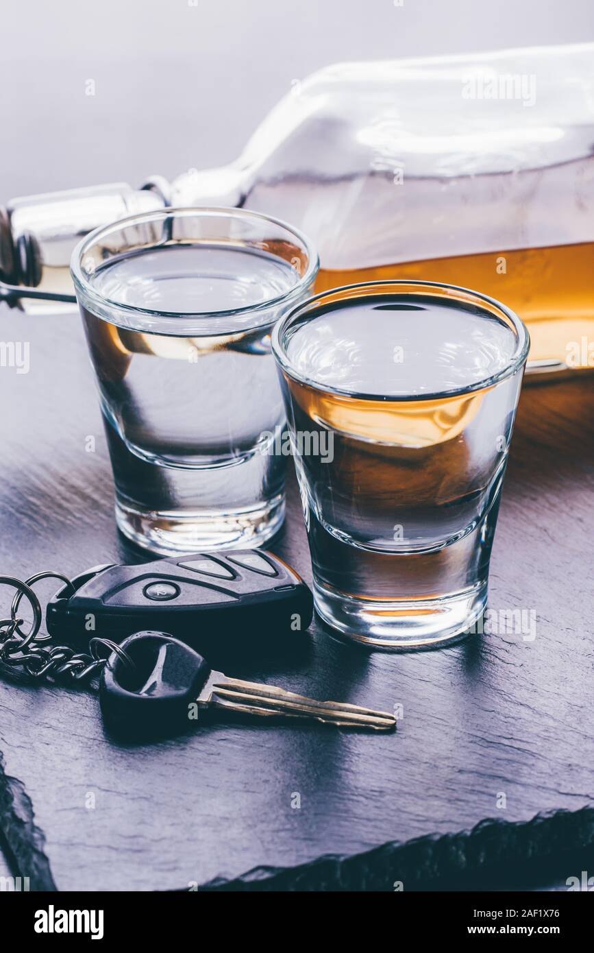 Verres avec de l'alcool et des clés de voiture sur fond sombre Banque D'Images