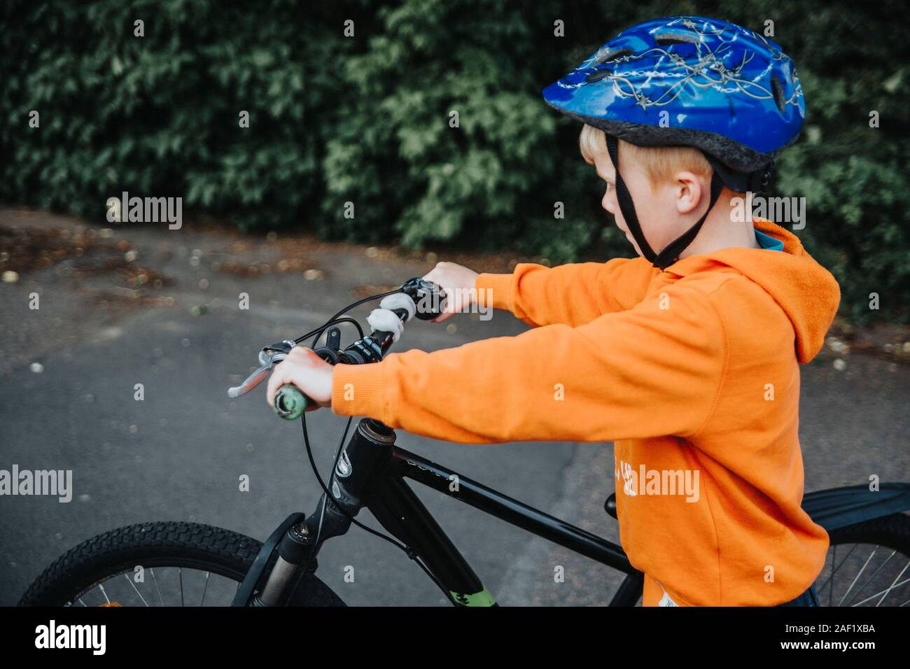 Poussant son vélo garçon Banque D'Images