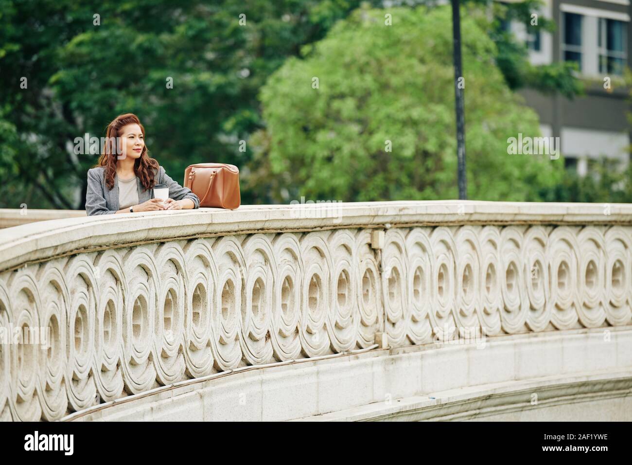 Belle Vietnamese woman standing on bridge avec une tasse de café à emporter et profiter de belle vue Banque D'Images