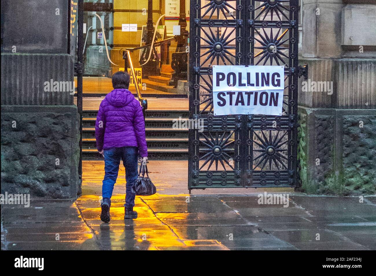 Femme à Preston, Lancashire. Météo au Royaume-Uni; 12 décembre 2019 les électeurs arrivent tôt le matin à la station de vote du Harris Museum, Art Gallery, pour enregistrer leurs votes à l'élection générale. Banque D'Images