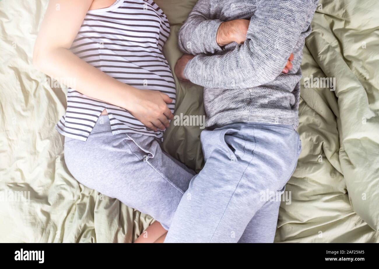 Young pregnant woman sleeping in bed sur matin ensoleillé. Les rayons du soleil brillent à travers la fenêtre. Position confortable pour dormir. Vue d'en haut. La vie le minimalisme Banque D'Images