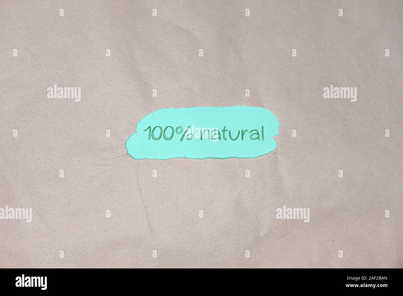texte « 100 % naturel » sur fond de papier d'emballage vert marron. Banque D'Images