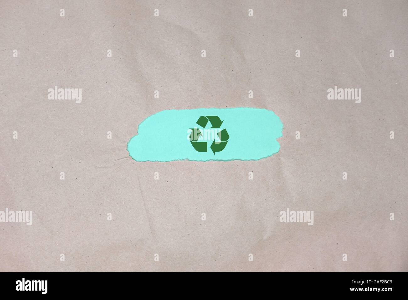 symbole recyclage sur fond de papier d'emballage vert marron. Banque D'Images