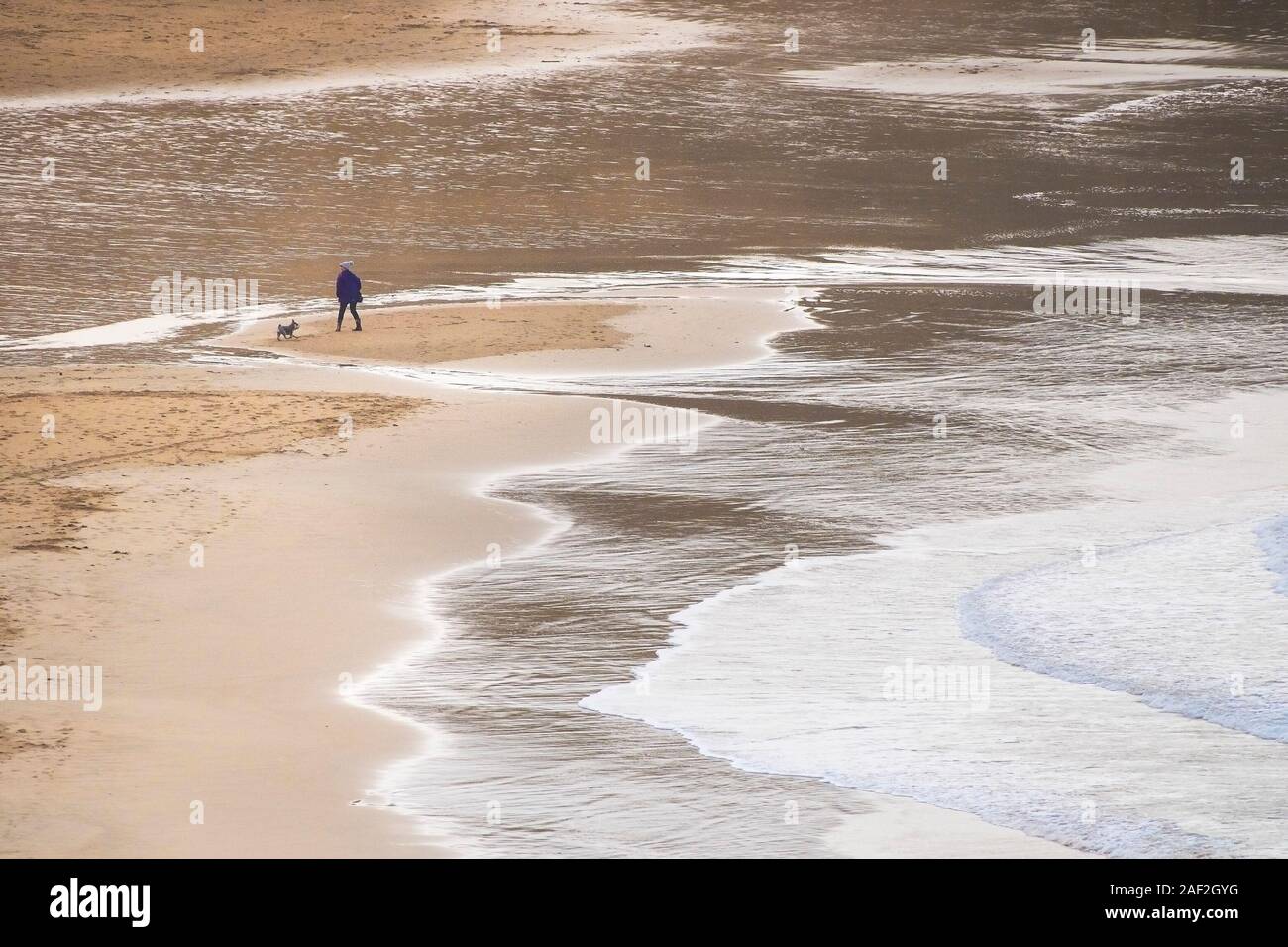 Un chien Walker et son petit chien à plage de Crantock en Newquay en Cornouailles. Banque D'Images