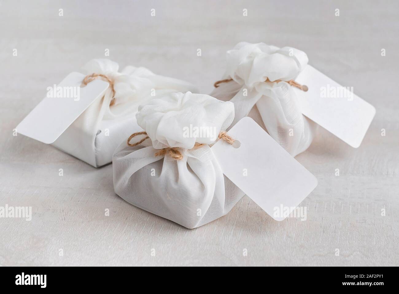 Cadeau de Noël enveloppé de tissu blanc furoshiki avec étiquettes. Eco  friendly don Photo Stock - Alamy
