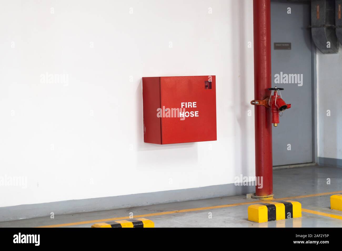 Les lances à incendie emballés à l'intérieur d'urgence rouge fort au mur Banque D'Images