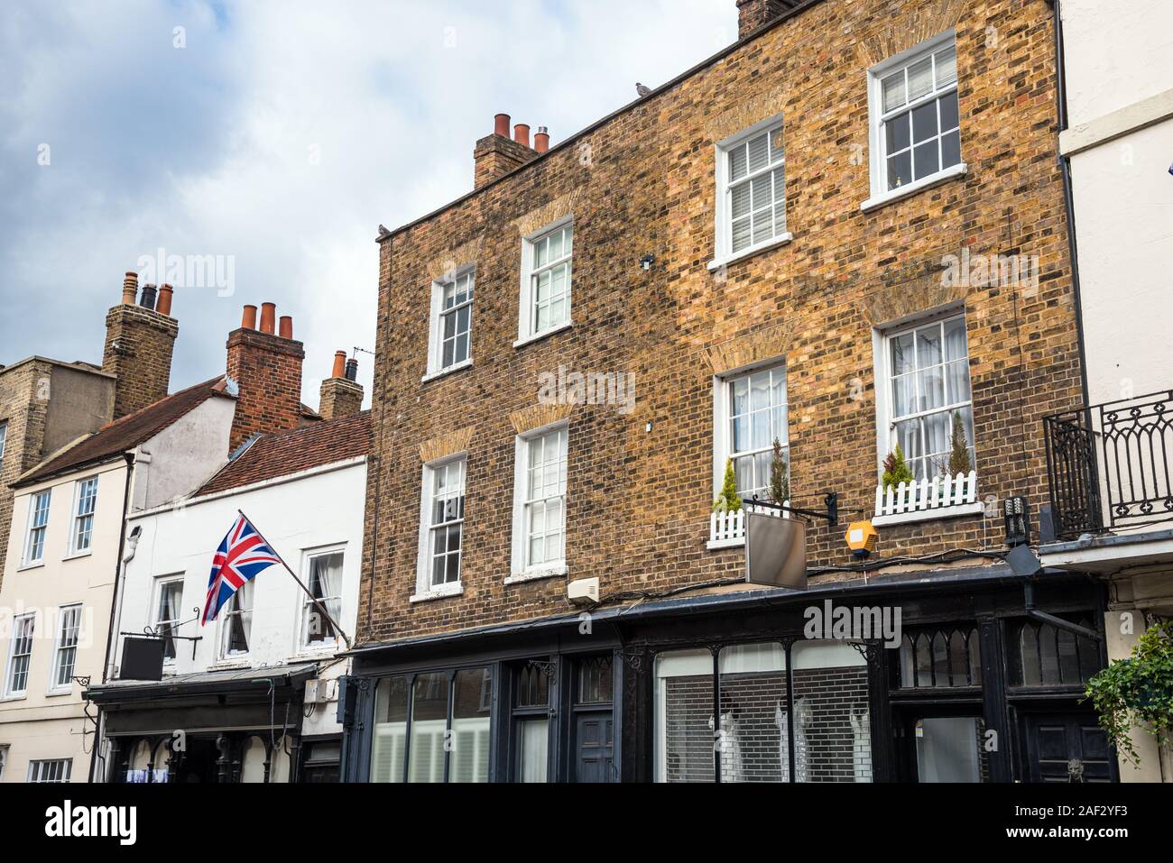 Bâtiments résidentiels britannique traditionnel, avec des commerces au rez-de-chaussée dans un centre ville, sur un jour de printemps ensoleillé Banque D'Images
