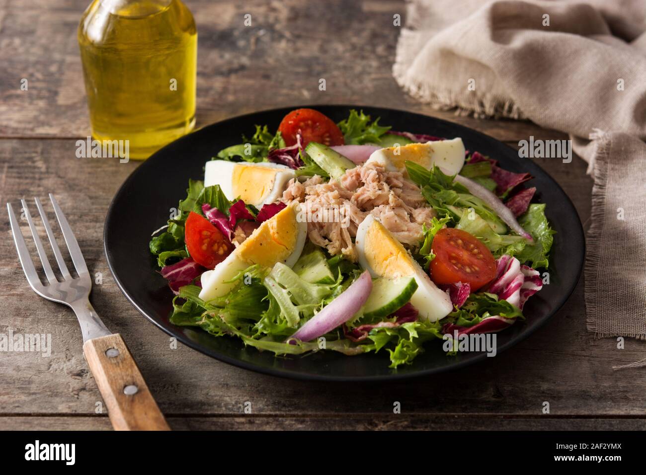 Salade avec des oeufs, du thon et légumes sur table en bois Banque D'Images
