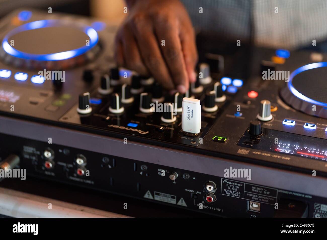 Club DJ joue de la musique sur scène en boite.Main de disc jockey son réglage de volume.L'équipement audio professionnel sur music festival Banque D'Images