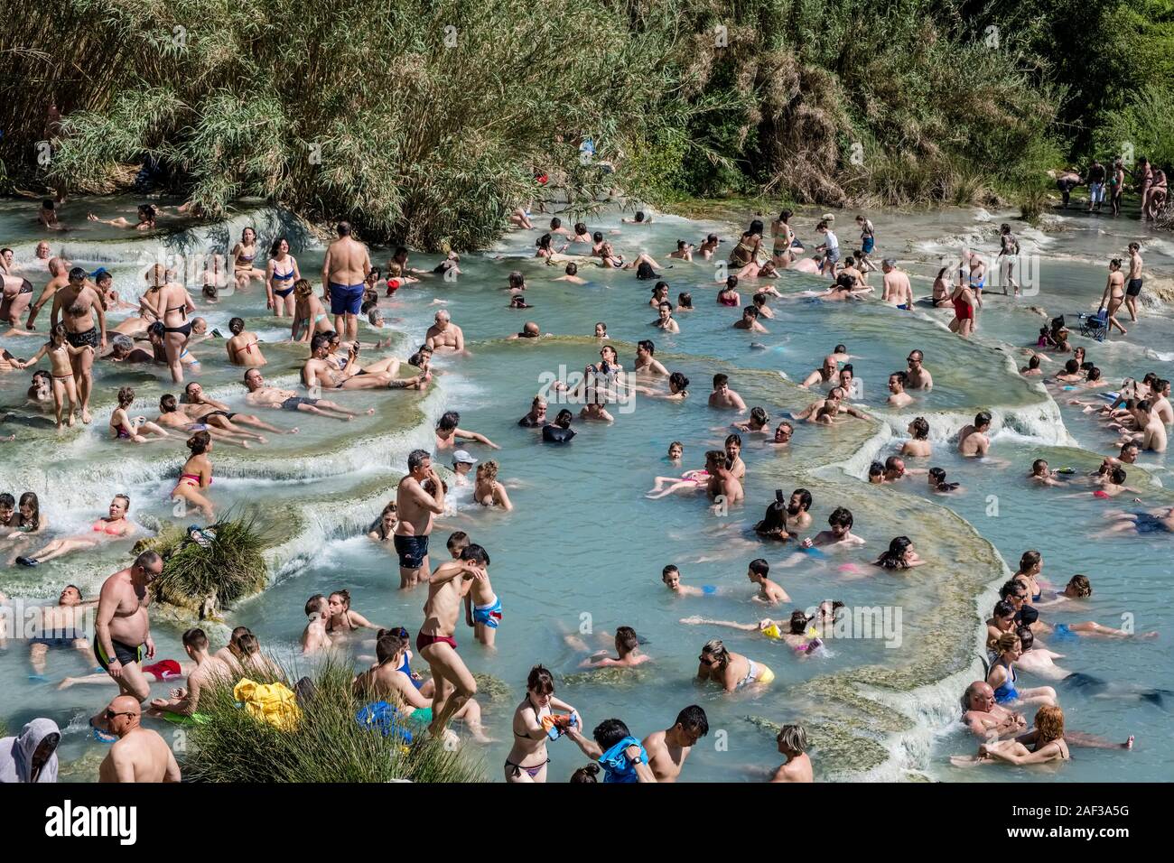 Beaucoup de gens sont de détente dans les cascades blanches remplies d'eaux sulfureuses des sources thermales Banque D'Images