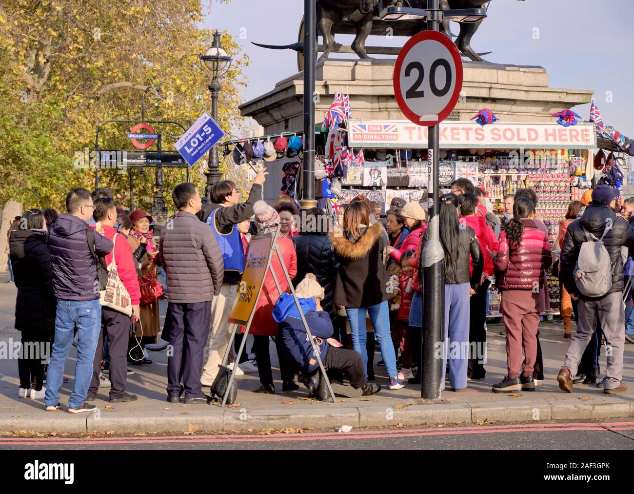 Tour guide élève son numéro de groupe, d'un drapeau (L01-5) avec les touristes rassemblement autour de Westminster à Londres Banque D'Images