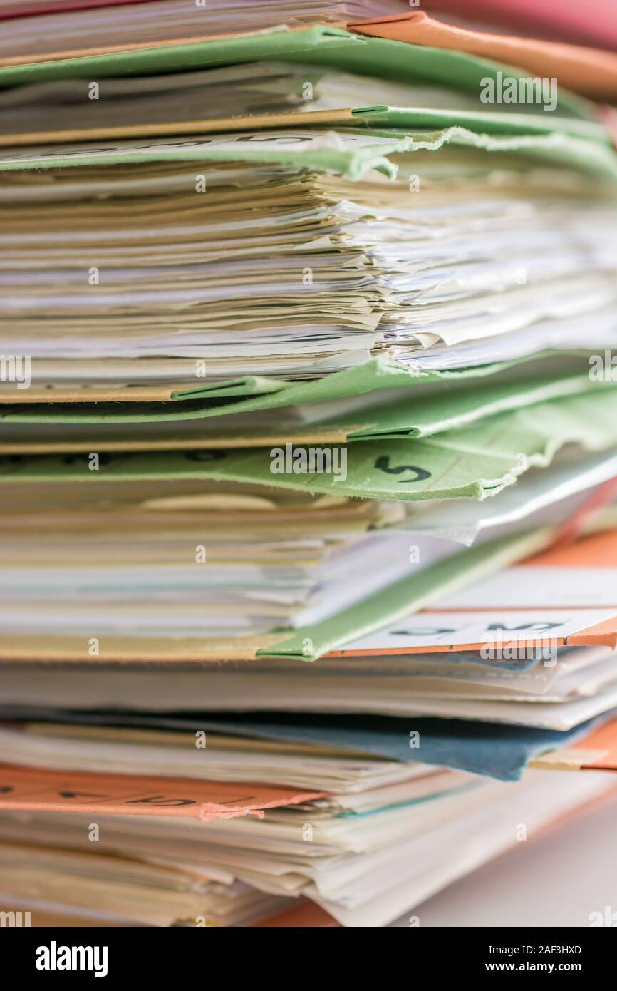 Montagnes de fichier sur un bureau dans le bureau comme un symbole de beaucoup de travail Banque D'Images