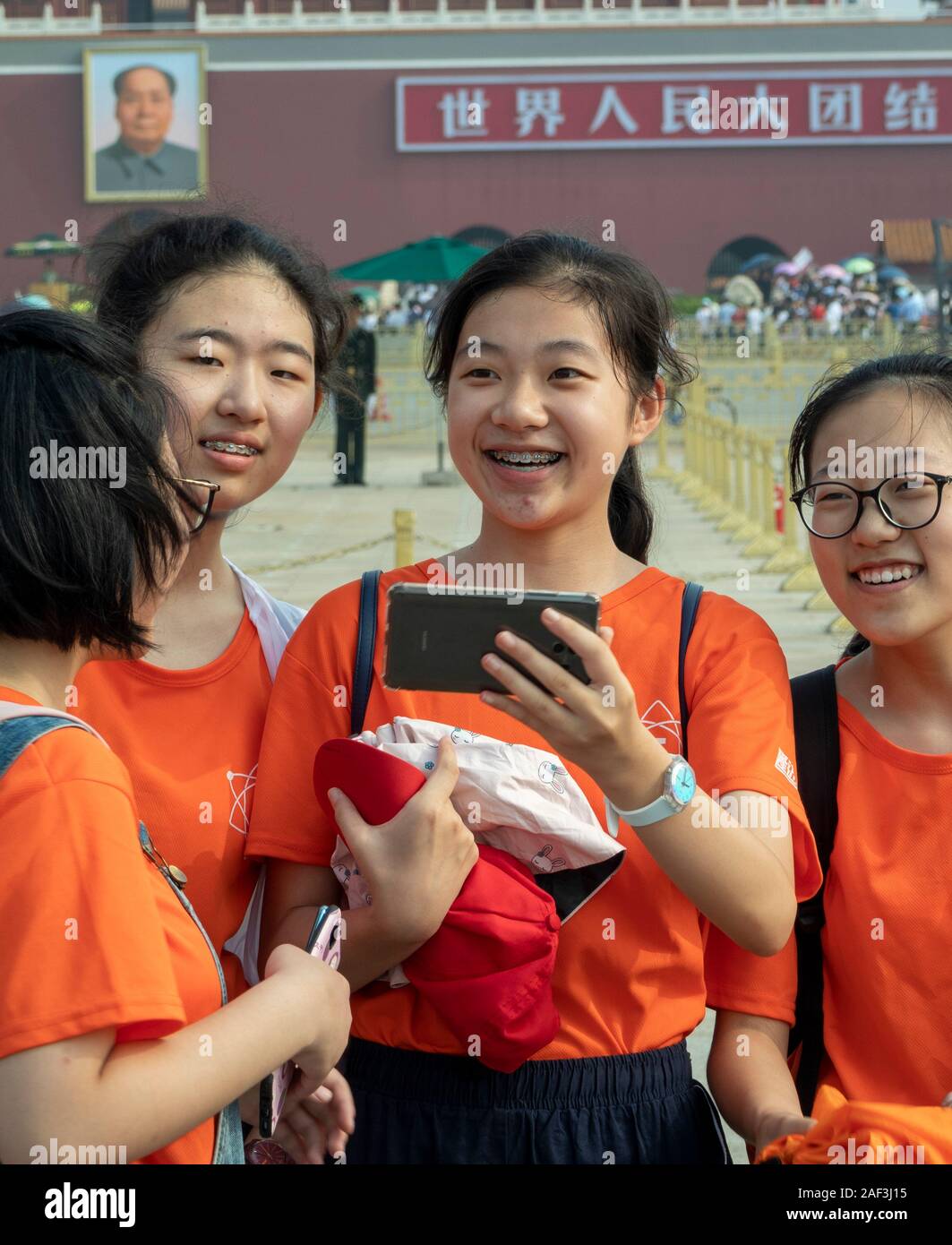 Les écoliers en tenant vos autoportraits sur sur la sortie de classe à la place Tiananmen et la Cité Interdite, Pékin, Chine Banque D'Images