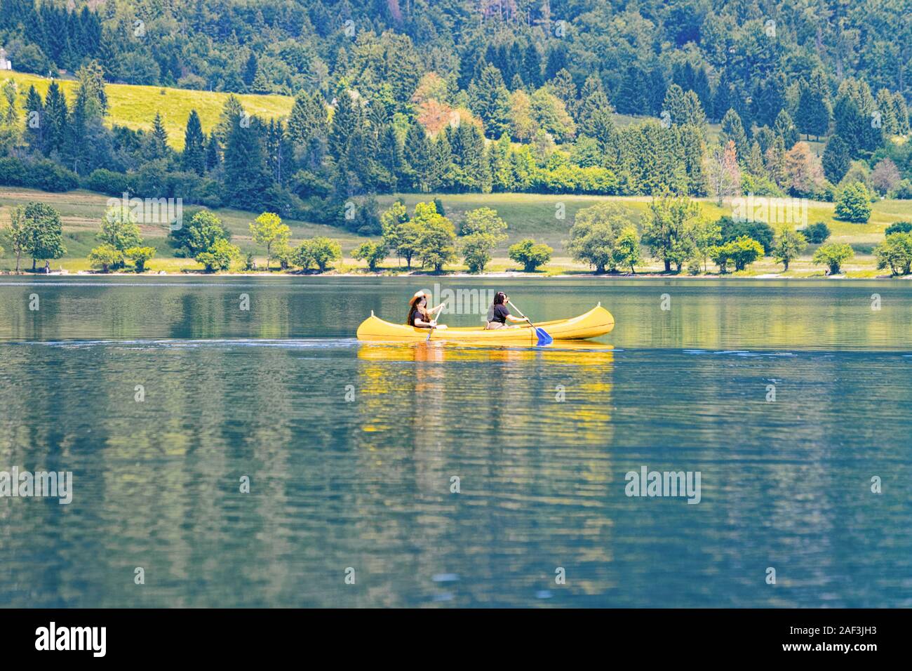 Décor de deux filles canoë dans le lac de Bohinj en Slovénie Banque D'Images